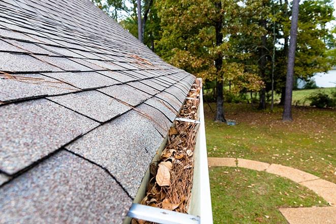 a person cleaning out gutters on a house